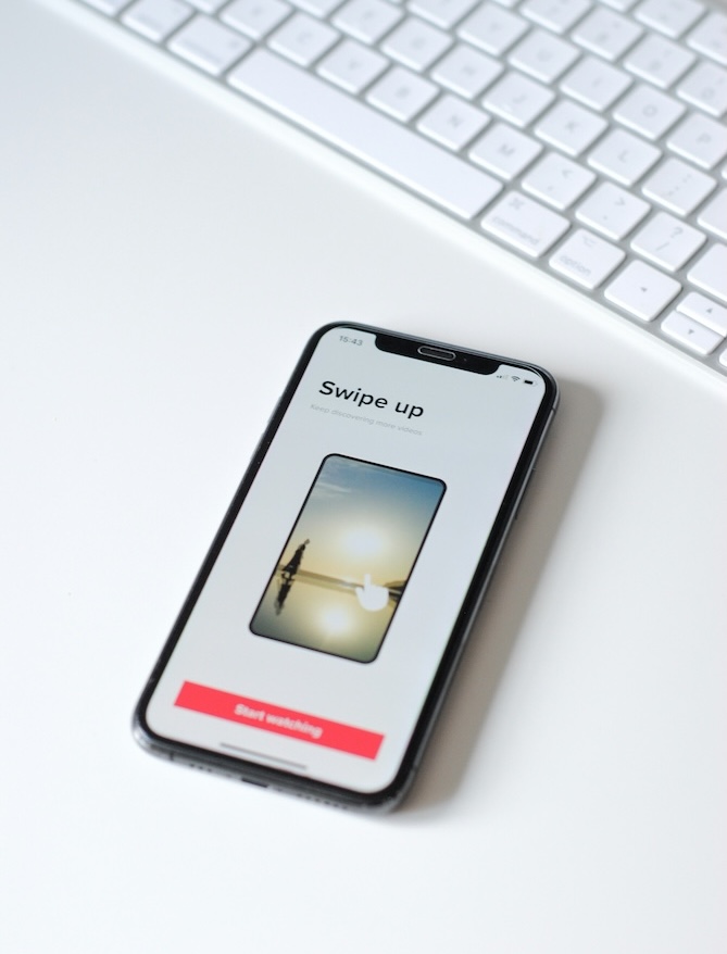 Hand holding a phone showing a stock watchlist